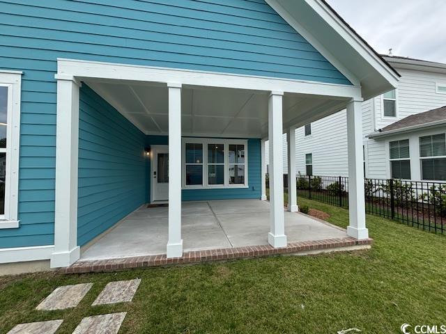 734 Macon Aly, Myrtle Beach, SC 29588 - back of house featuring a yard, concrete driveway, a garage, and an outdoor structure