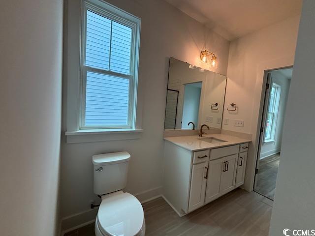 734 Macon Aly, Myrtle Beach, SC 29588 - bathroom with baseboards, toilet, vanity, and wood finished floors