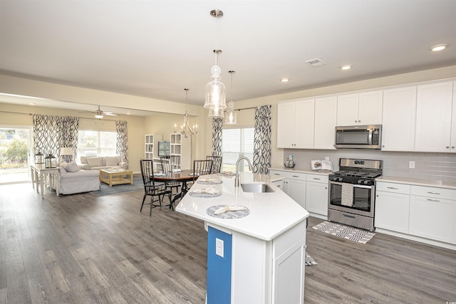 kitchen with pendant lighting, a kitchen island with sink, ceiling fan, white cabinetry, and stainless steel appliances