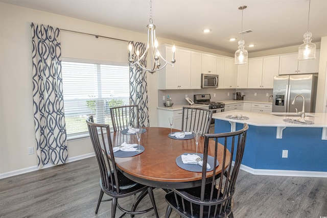 dining space with dark hardwood / wood-style flooring, a chandelier, and sink