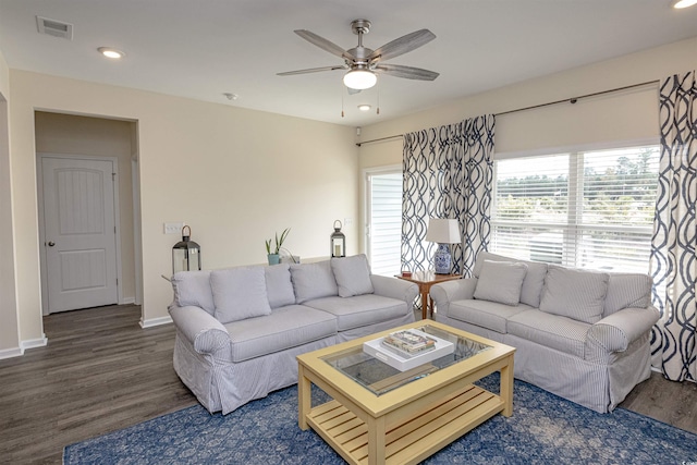 living room with ceiling fan and dark wood-type flooring