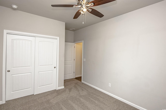 unfurnished bedroom featuring carpet flooring, ceiling fan, and a closet