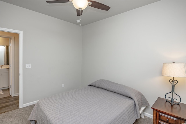 bedroom with ceiling fan, dark carpet, and connected bathroom