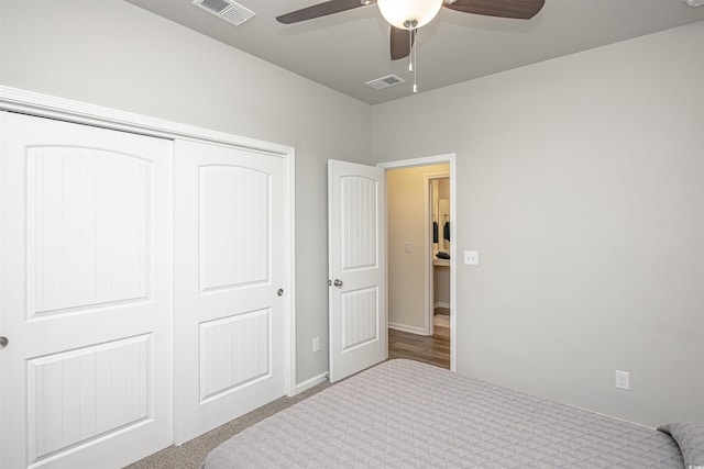 bedroom featuring ceiling fan, light colored carpet, and a closet