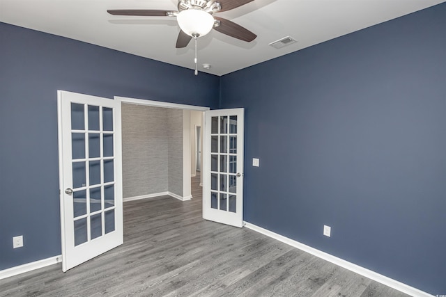 spare room featuring french doors, ceiling fan, and wood-type flooring