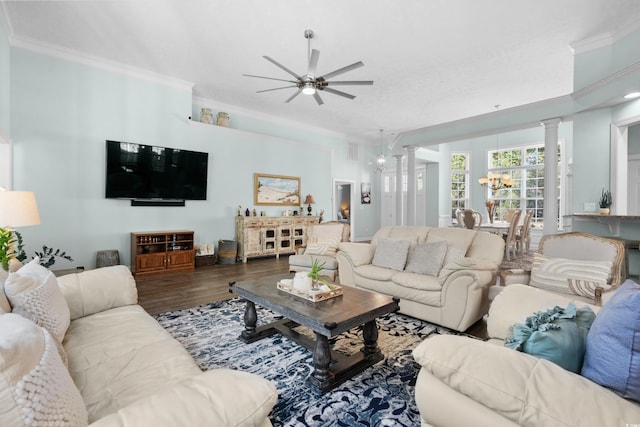 living room with hardwood / wood-style floors, ceiling fan with notable chandelier, ornate columns, and ornamental molding