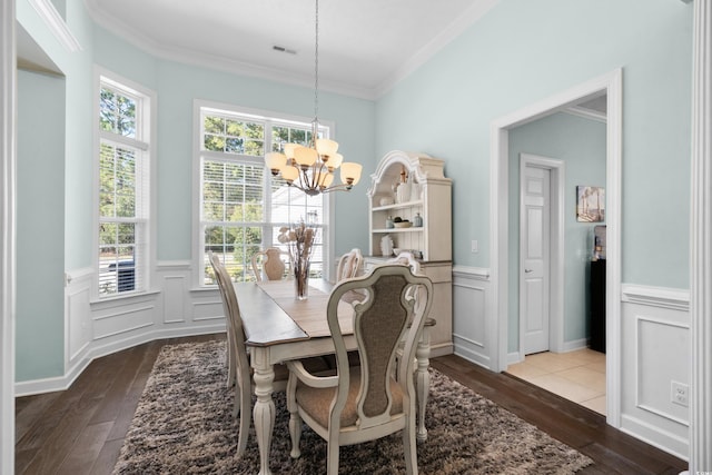 5012 Lindrick Ct, Myrtle Beach, SC 29579 - dining area featuring dark wood-style flooring, a notable chandelier, a wainscoted wall, and a healthy amount of sunlight