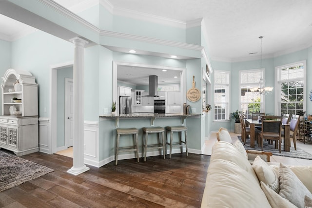 5012 Lindrick Ct, Myrtle Beach, SC 29579 - living area with baseboards, a chandelier, ornate columns, crown molding, and dark wood-type flooring