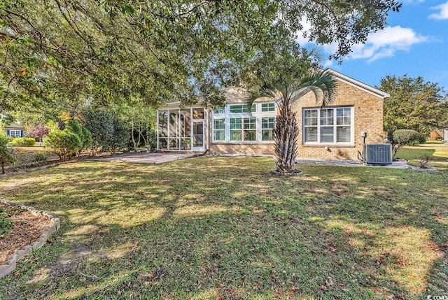 back of property with a patio area, a lawn, cooling unit, and a sunroom