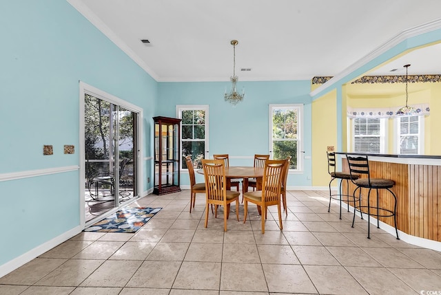 dining room featuring light tile patterned flooring, crown molding, a wealth of natural light, and an inviting chandelier