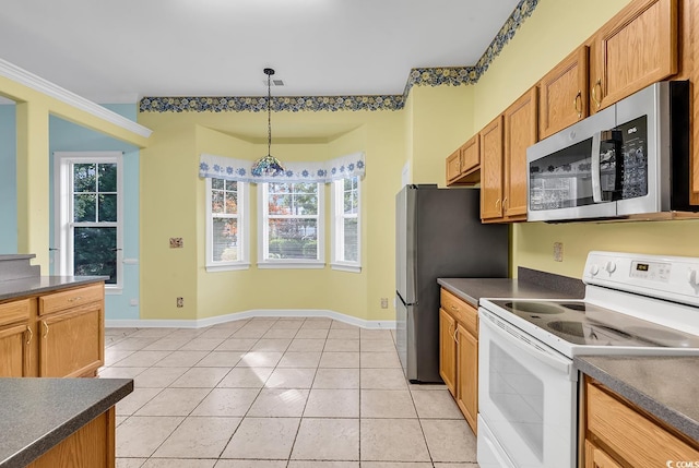 kitchen featuring pendant lighting, a wealth of natural light, light tile patterned floors, and appliances with stainless steel finishes