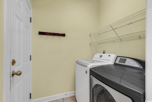 washroom with washer and clothes dryer and light tile patterned flooring