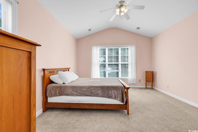 bedroom with light carpet, vaulted ceiling, multiple windows, and ceiling fan