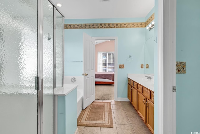 bathroom featuring tile patterned flooring, vanity, and shower with separate bathtub