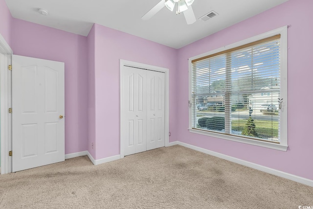 unfurnished bedroom featuring carpet flooring, ceiling fan, and a closet