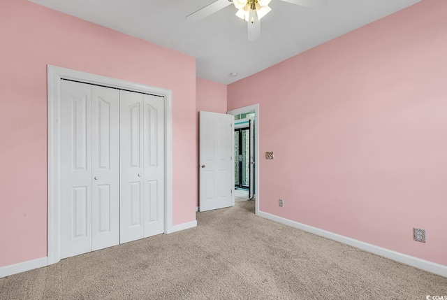 unfurnished bedroom featuring ceiling fan, light carpet, and a closet