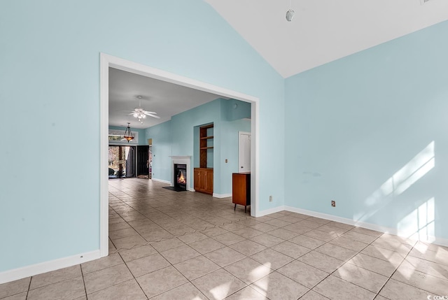 tiled empty room with ceiling fan and high vaulted ceiling