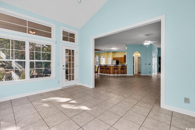 interior space with ceiling fan, light tile patterned flooring, and high vaulted ceiling