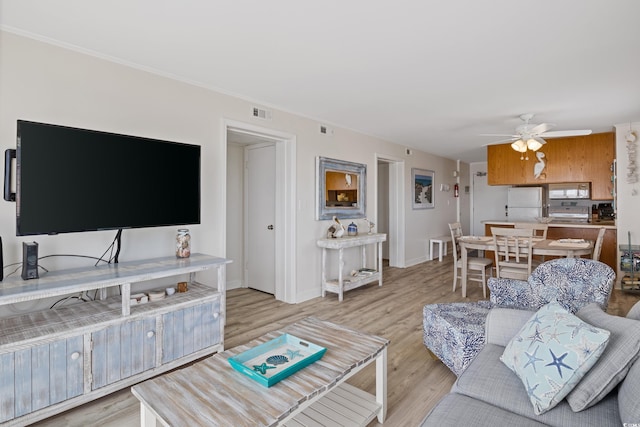 living room with ceiling fan and light hardwood / wood-style floors