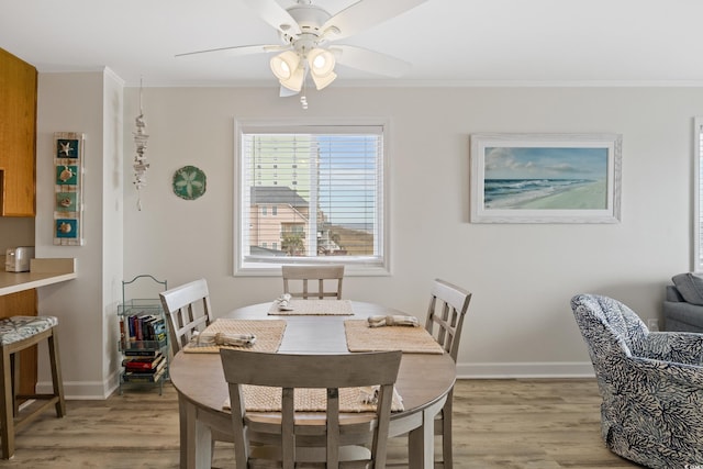 dining space featuring ceiling fan, crown molding, and light hardwood / wood-style flooring