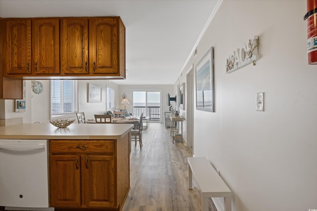 kitchen with kitchen peninsula, white dishwasher, and light hardwood / wood-style flooring