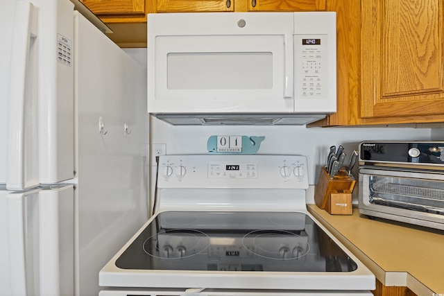 kitchen featuring white cabinetry and white appliances