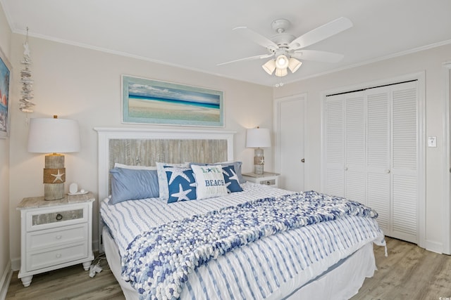 bedroom with a closet, light hardwood / wood-style flooring, ceiling fan, and ornamental molding