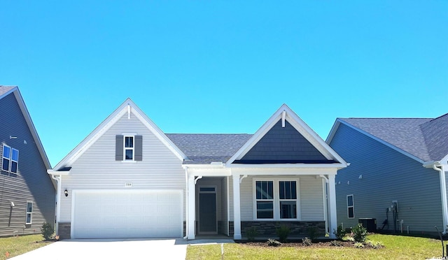 view of front of property featuring a front yard, central AC unit, and a garage