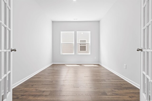 empty room featuring french doors and dark hardwood / wood-style floors