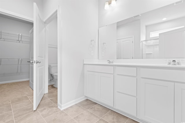 bathroom with tile patterned flooring, vanity, toilet, and a shower with shower door