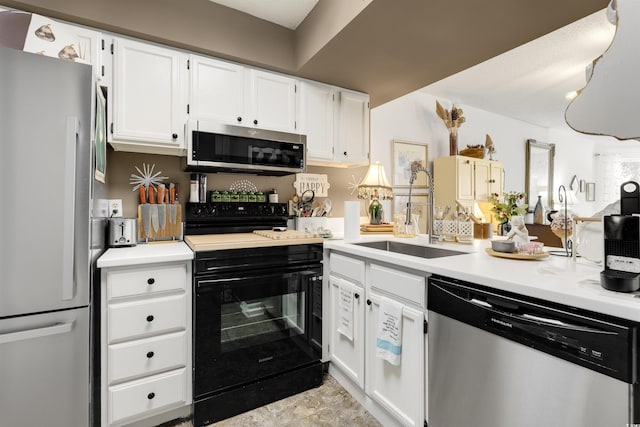 kitchen with appliances with stainless steel finishes, sink, and white cabinets