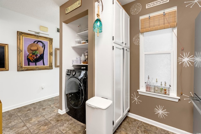 laundry area featuring a textured ceiling and washer / clothes dryer