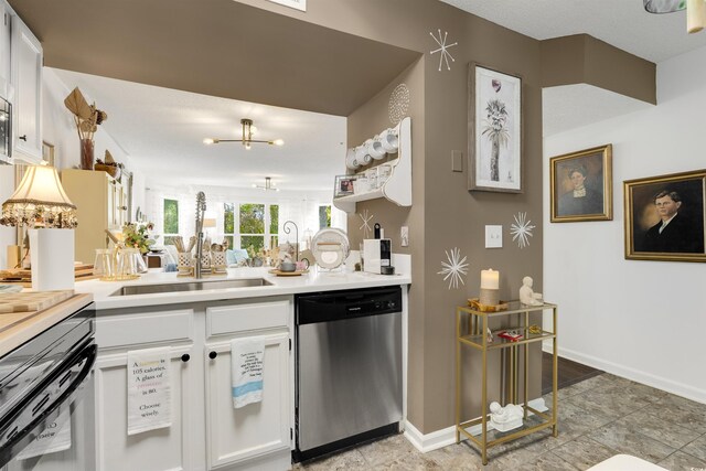 kitchen featuring a chandelier, white cabinetry, stainless steel dishwasher, and sink