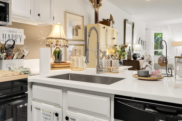 kitchen featuring dishwasher, sink, a notable chandelier, a textured ceiling, and white cabinets