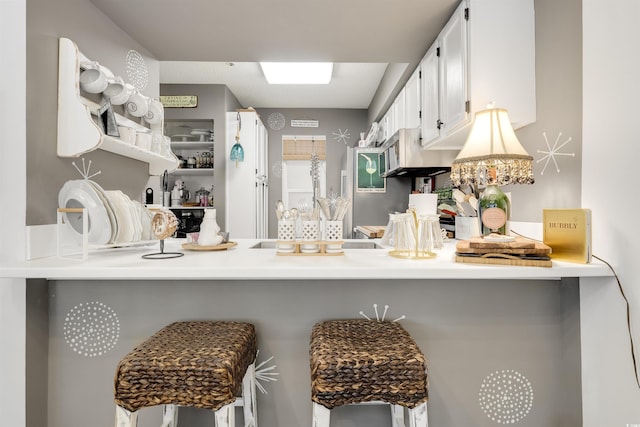 kitchen with white cabinetry, kitchen peninsula, and a breakfast bar