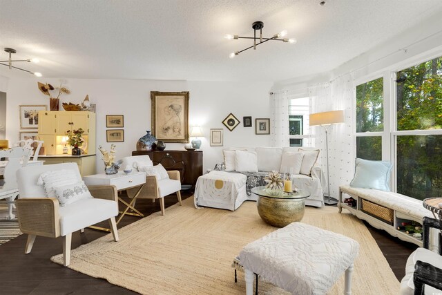 living room with a chandelier, a textured ceiling, and hardwood / wood-style flooring