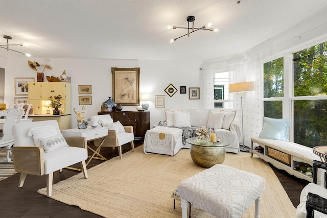 living room with hardwood / wood-style flooring, a chandelier, and a textured ceiling