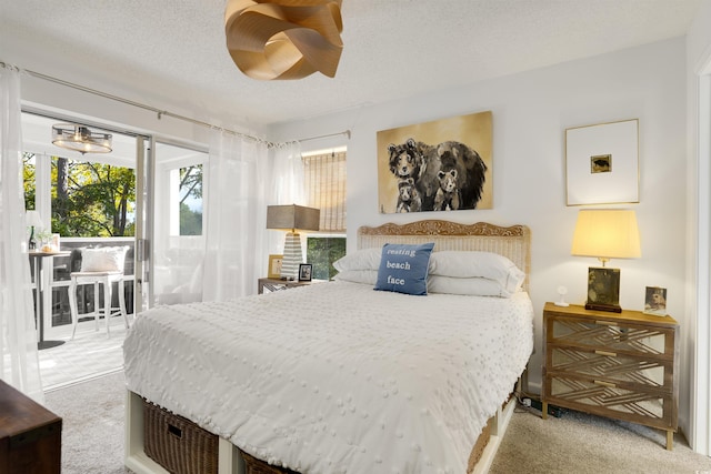 bedroom featuring access to exterior, hardwood / wood-style floors, and a textured ceiling