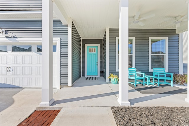 doorway to property with ceiling fan, a garage, and covered porch