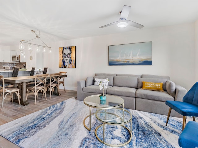 living room with ceiling fan and light hardwood / wood-style flooring