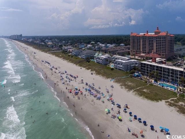 birds eye view of property with a water view and a beach view