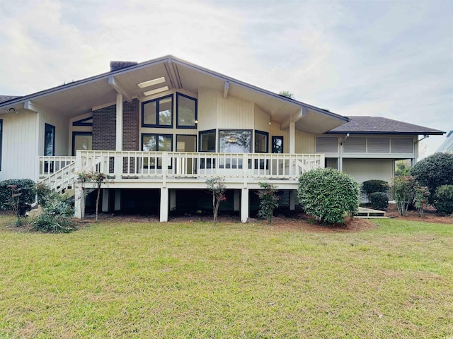 back of property with a lawn and a deck