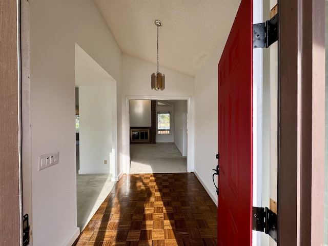 hallway featuring a chandelier, dark parquet flooring, and vaulted ceiling