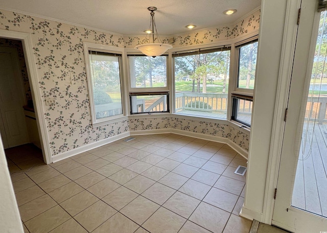 spare room featuring light tile patterned floors, visible vents, baseboards, and wallpapered walls