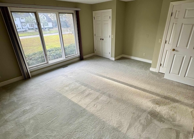 unfurnished bedroom with light carpet, visible vents, and baseboards