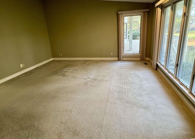 carpeted spare room with visible vents and baseboards