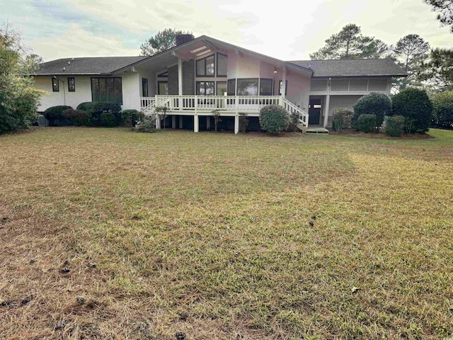 rear view of house with a wooden deck and a yard