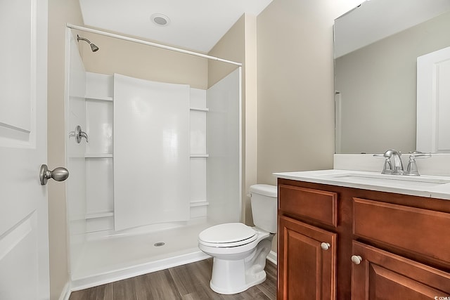 bathroom with a shower, vanity, hardwood / wood-style flooring, and toilet