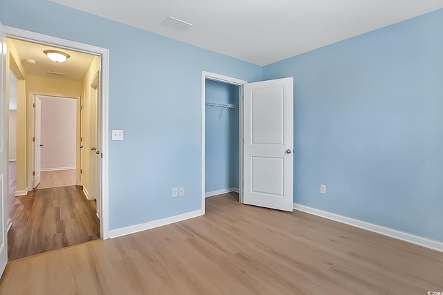 unfurnished bedroom with a closet and light hardwood / wood-style flooring