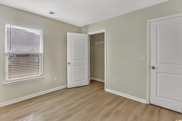 unfurnished bedroom featuring light wood-type flooring and a closet